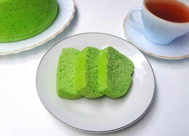 白色盘子上的清蒸香兰饼，配上一杯热茶。下午茶或喝茶时间图片下载