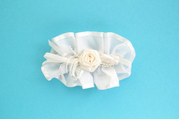 手工白色婚礼头发蝴蝶结发夹在蓝色的背景。优雅时尚设计的女性配件图片下载