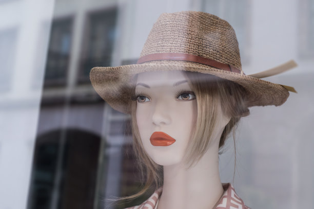 时装店陈列室里，模特头上的夏帽图片下载