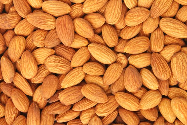 一堆杏仁种子特写作为背景。一堆去皮的杏仁。健康饮食，营养饮食，素食理念图片下载