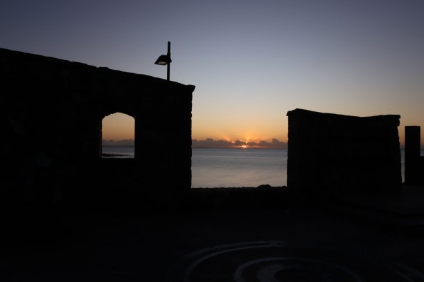 透过剪影墙的日出图片下载