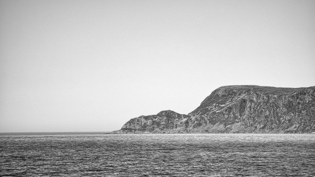 从大海到挪威西开普省在阳光下的黑白照片。图片下载