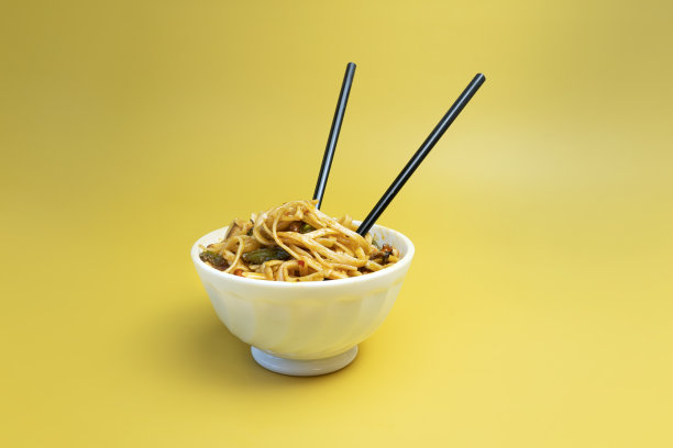 黄底乌冬炒鸡芝麻面。明亮的黄色背景色。图片下载