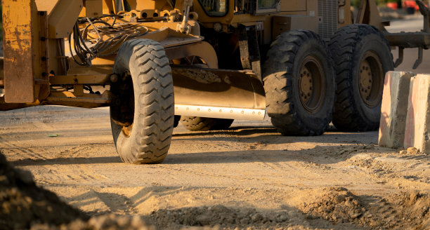 修路师在工地维修及建造土路及碎石路。黄色平地机。道路定级用重型机械及施工设备。年级的机器。图片下载