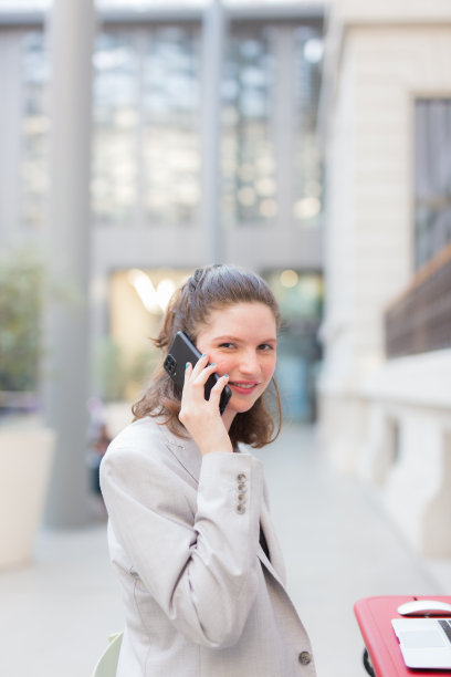 坐在露台上玩手机的快乐女人图片下载