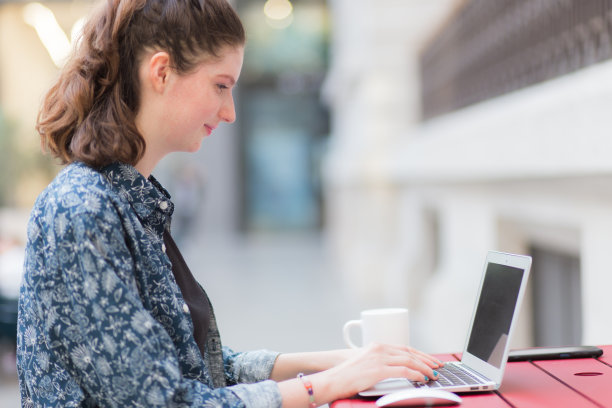 年轻女子在咖啡馆使用笔记本电脑图片下载