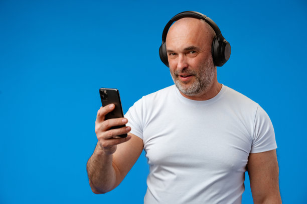 积极开朗的男人的肖像音乐爱好者听收音机歌曲在蓝色的背景图片下载