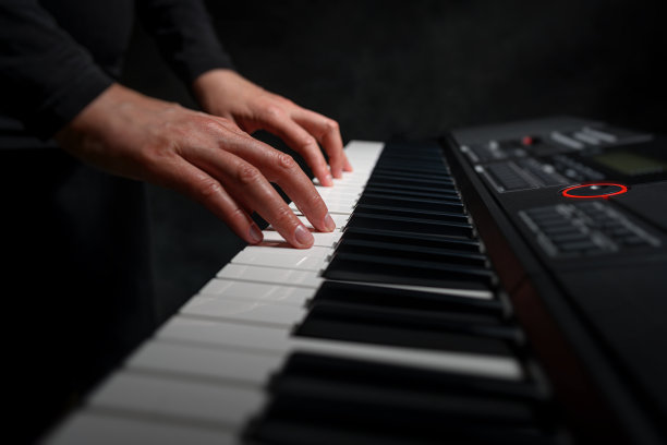 在黑暗的背景下弹奏钢琴合成器图片下载