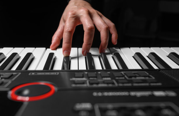 在黑暗的背景下弹奏钢琴合成器图片下载