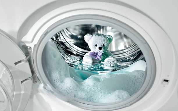 泰迪熊在洗衣机里洗泡泡浴图片下载
