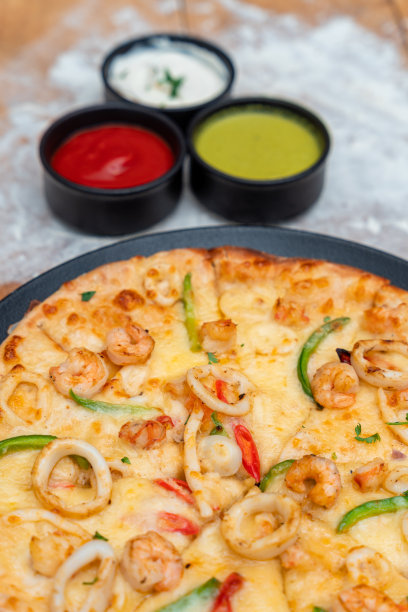 披萨配虾、鲑鱼、鱿鱼和橄榄。俯视图图片下载