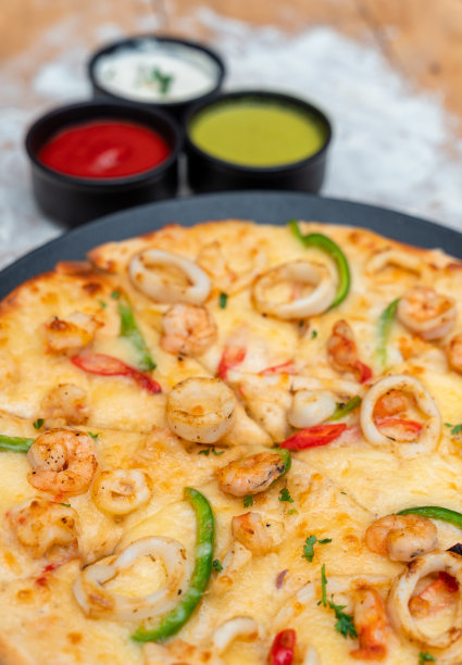 披萨配虾、鲑鱼、鱿鱼和橄榄。俯视图图片下载