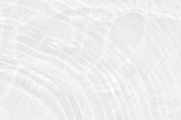 水面泛起涟漪的白水。散焦模糊透明白色彩色清澈平静水面纹理飞溅和气泡。水波与闪亮的图案纹理背景。图片下载