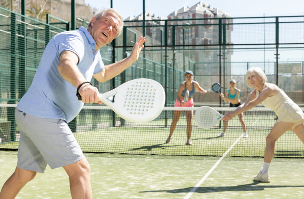 在网球场打板式网球的老人回头看球图片下载