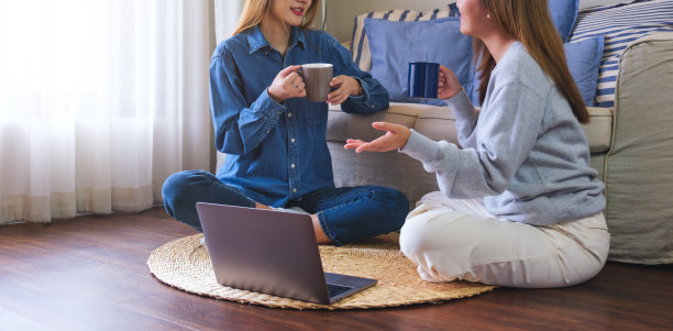 两个亚洲女人在家里用笔记本电脑聊天和工作的特写图片下载