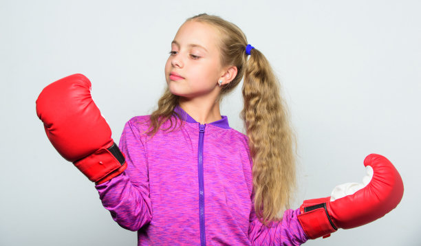孩子练拳，健康健身。击倒和能量。运动的成功。运动和运动服装时尚。小女孩戴着拳击手套出拳。跟着教练训练。战斗。我准备好战斗了图片下载
