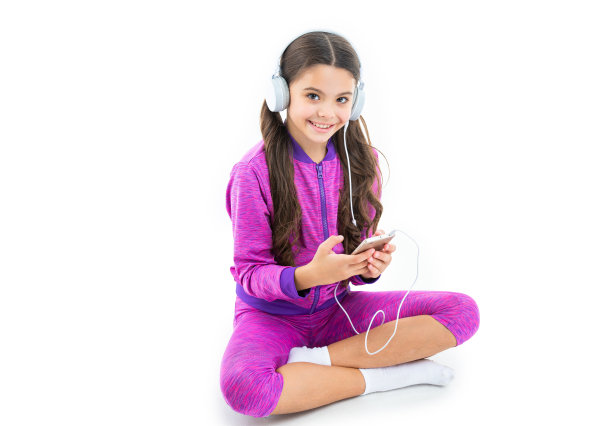 开朗的少女在后台使用音乐应用程序。十几岁的女孩使用手机上的音乐应用程序的照片。图片下载