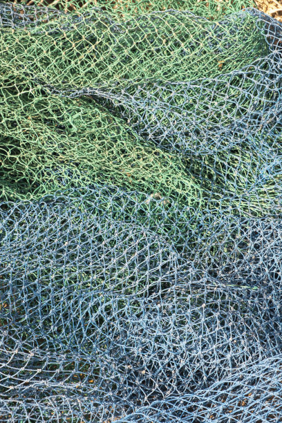 从一艘堆放在渔港的船上，仔细观察工业捕鱼中使用的渔网、浮标和其他物品。图片下载