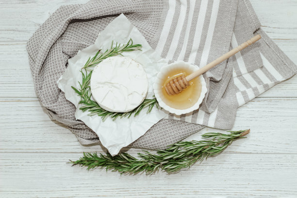卡芒贝尔奶酪，桌上放着迷迭香和蜂蜜图片下载