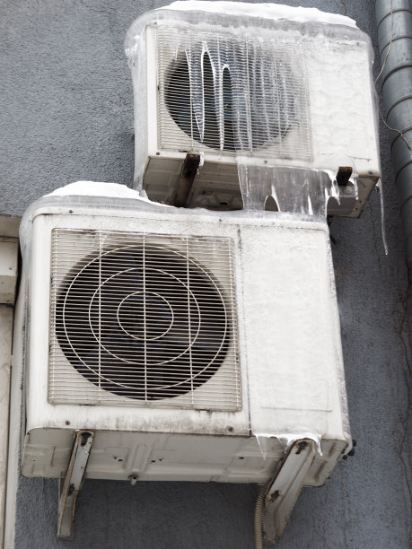 分体式空调室外机变频压缩机组安装在楼外。设备在冬季结冰。高质量照片图片下载