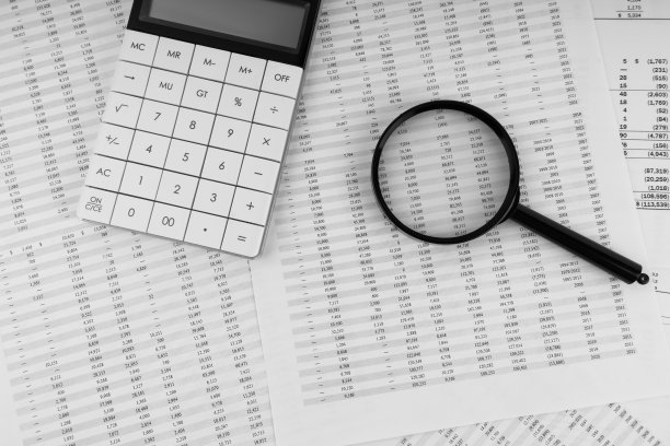 财务报表的计算器和放大镜。财务、会计和商业概念。图片下载
