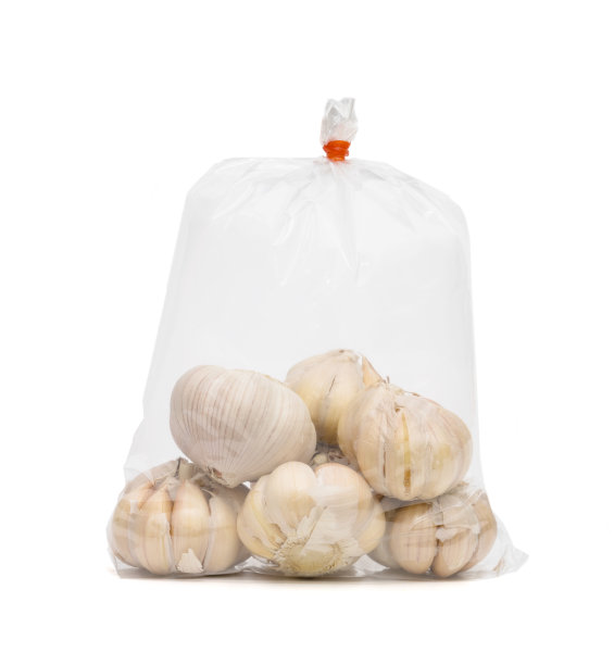大蒜装在白色背景的塑料袋里图片下载