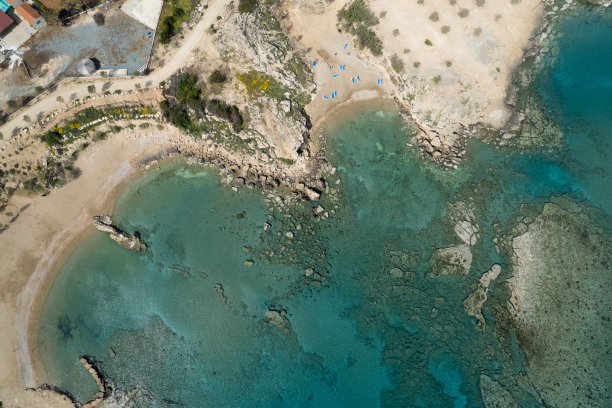 无人机拍摄的沙滩伞和人们在海里游泳的照片。暑假在海边图片下载