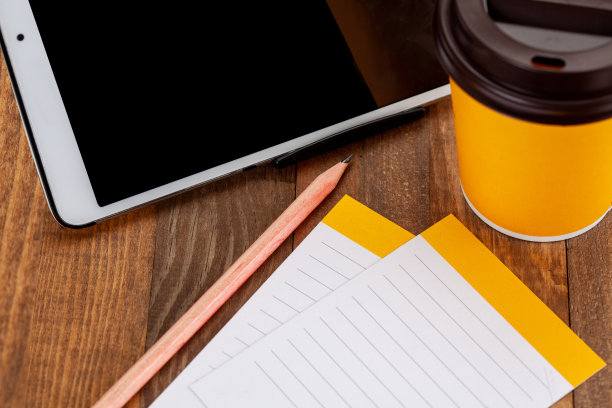 平板电脑屏幕，咖啡，笔和笔记本在木地板上图片下载