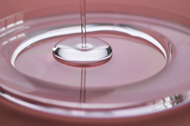 粉红色背景上的一滴多汁凝胶。图片下载