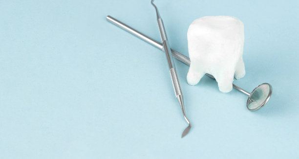 蓝色背景的牙齿模型和牙医的医疗设备工具。口腔卫生。治疗的概念。牙医工具。牙科设备。图片下载