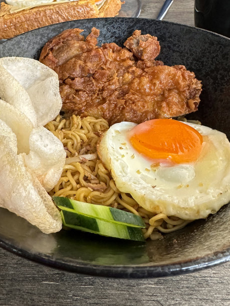 特写图片:斑驳的灰色碗里装着油炸的、打烂的鸡肉、面条、煎蛋、黄瓜和虾饼干，高架视图，聚焦于前景图片下载