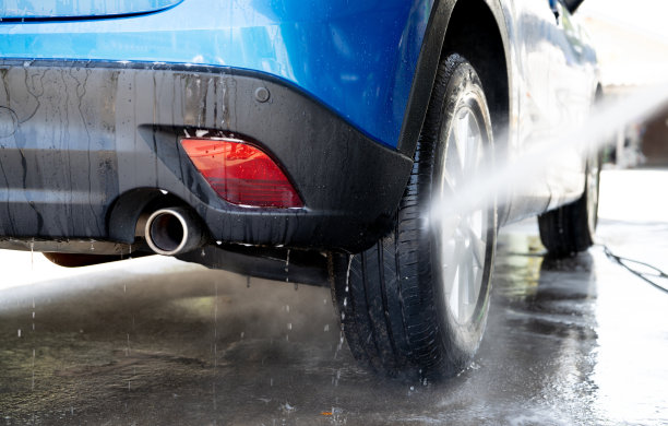 洗车用高压水喷淋。汽车清洗。汽车护理服务理念。车辆清洗。汽车车轮、轮胎高压喷水。用高压水手动洗车。图片下载