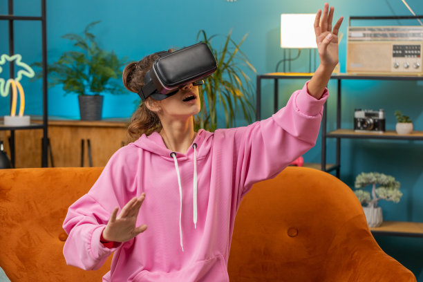 十几岁的女孩使用虚拟现实未来科技耳机在家玩模拟3D视频游戏图片下载