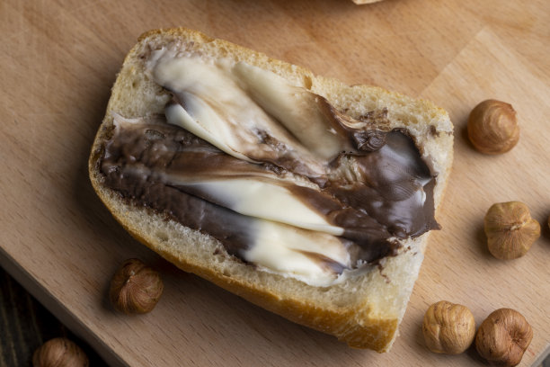 桌上放着涂了巧克力黄油的面包片图片下载