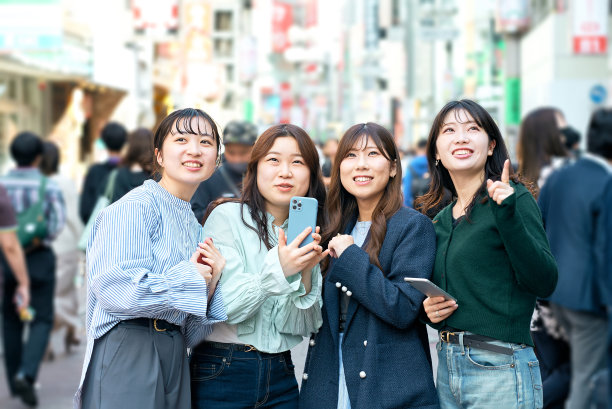 年轻女性在城市中使用智能手机图片下载