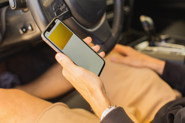 男子手里拿着手机。车内背景。非接触式支付。智能手机。在线购物。汽车共享图片下载