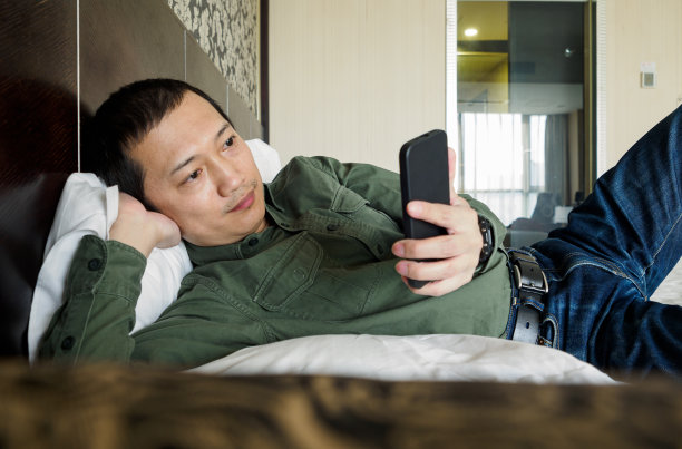 躺在床上玩手机的男人图片下载