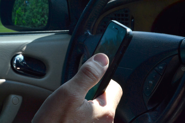 一个男人坐在车里，按了一下电话图片下载