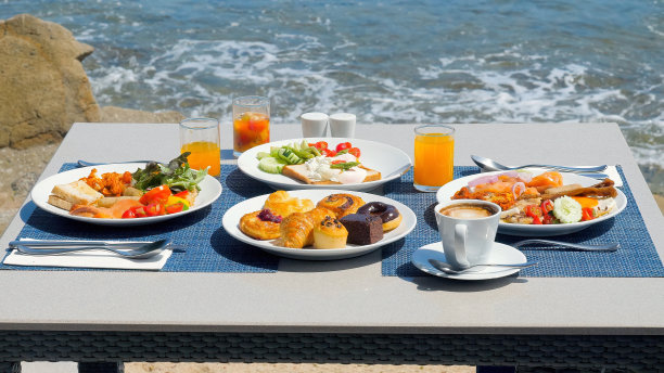 豪华早餐铺在桌子上与一个惊人的热带海景图片下载
