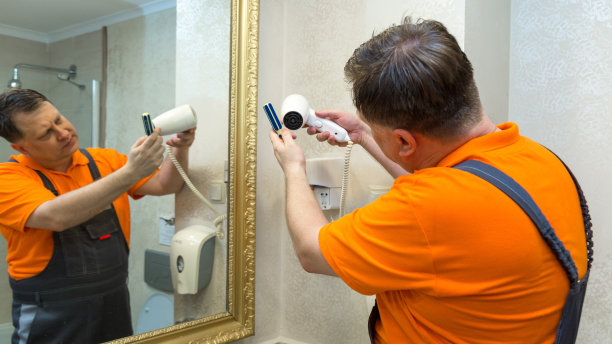 男子在浴室修理吹风机图片下载