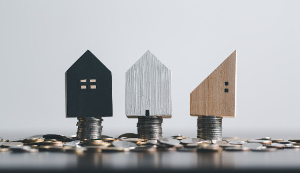 叠硬币和家庭模型放在办公室的顶部，商业投资贷款的房地产或节省资金，为未来购买新房的概念。计划购买房产。图片下载