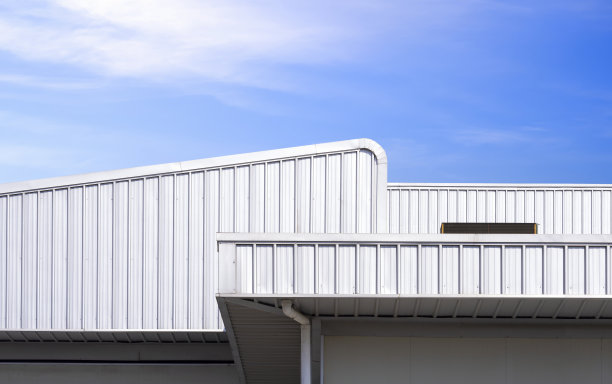 现代风格的工业仓库和工厂建筑的波纹铝屋顶，以蓝天为背景图片下载