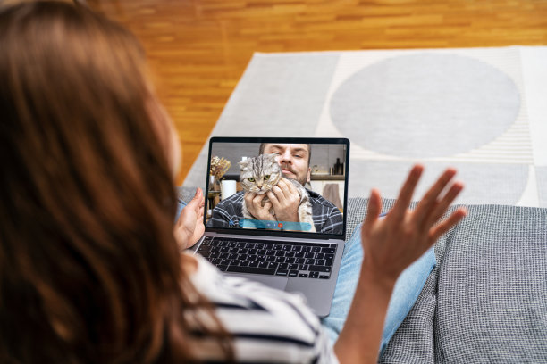 一个男人带着他的猫给他女朋友打电话。图片下载