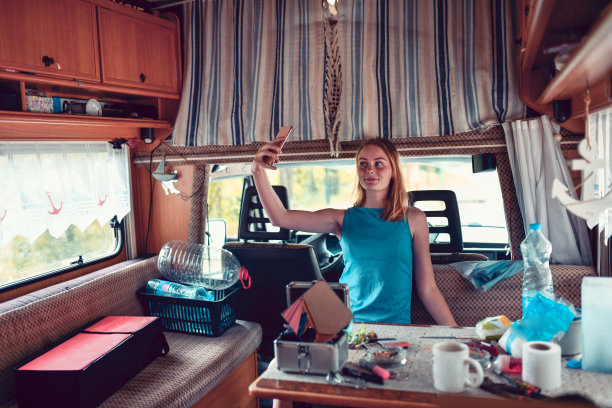 微笑的金发美女在房车里自拍图片下载