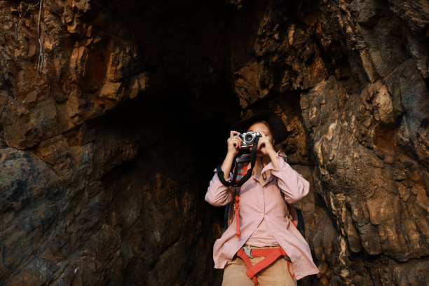小女孩在洞穴徒步探险旅行时用无反光镜相机拍摄美丽的景色图片下载