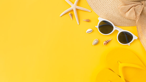 夏季时间概念，顶部视图与复制空间的太阳镜和海星帽子，黄色背景的人字拖。图片下载