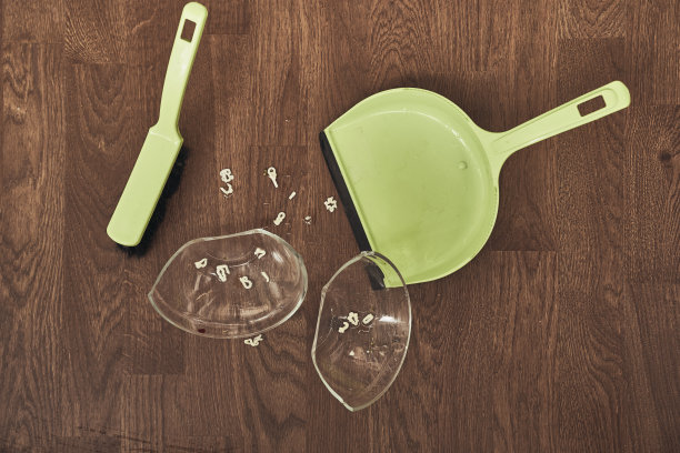 这是一个透明的杯子，上面有汤和刷子，还有一个簸箕用来清洁。公寓里的家庭清洁概念。高质量照片图片下载