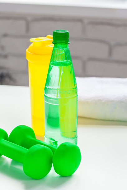 运动，健康的生活方式和物体的概念-哑铃，水瓶的特写图片下载