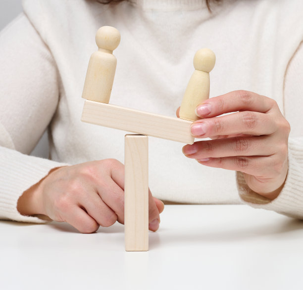 两个男人的木制雕像相对而立，象征着对手的和解，结束了霸凌图片下载