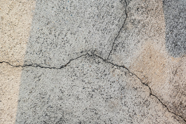这张照片显示了早晨混凝土路面上反射阳光的裂缝。图片下载
